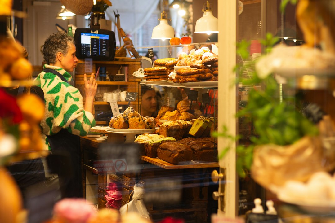 Person looking at baked goods in a small shop window